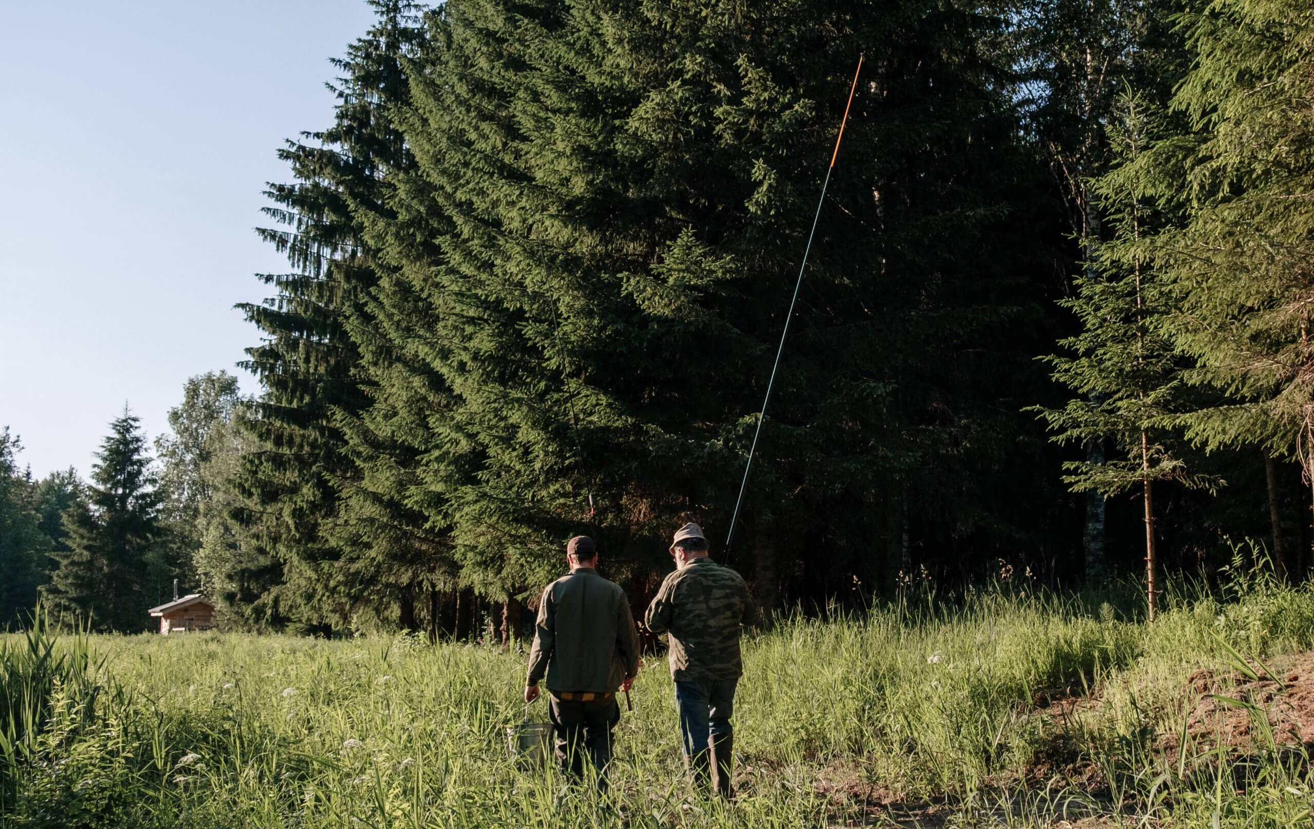 Father and Son walking through a meadow during fishing trip