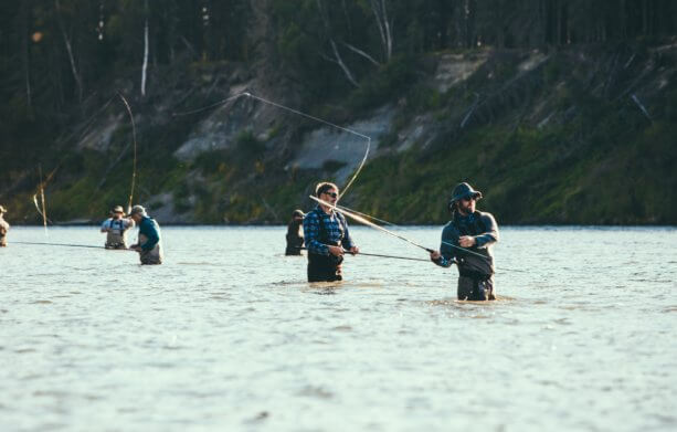 a group of men fly fishing