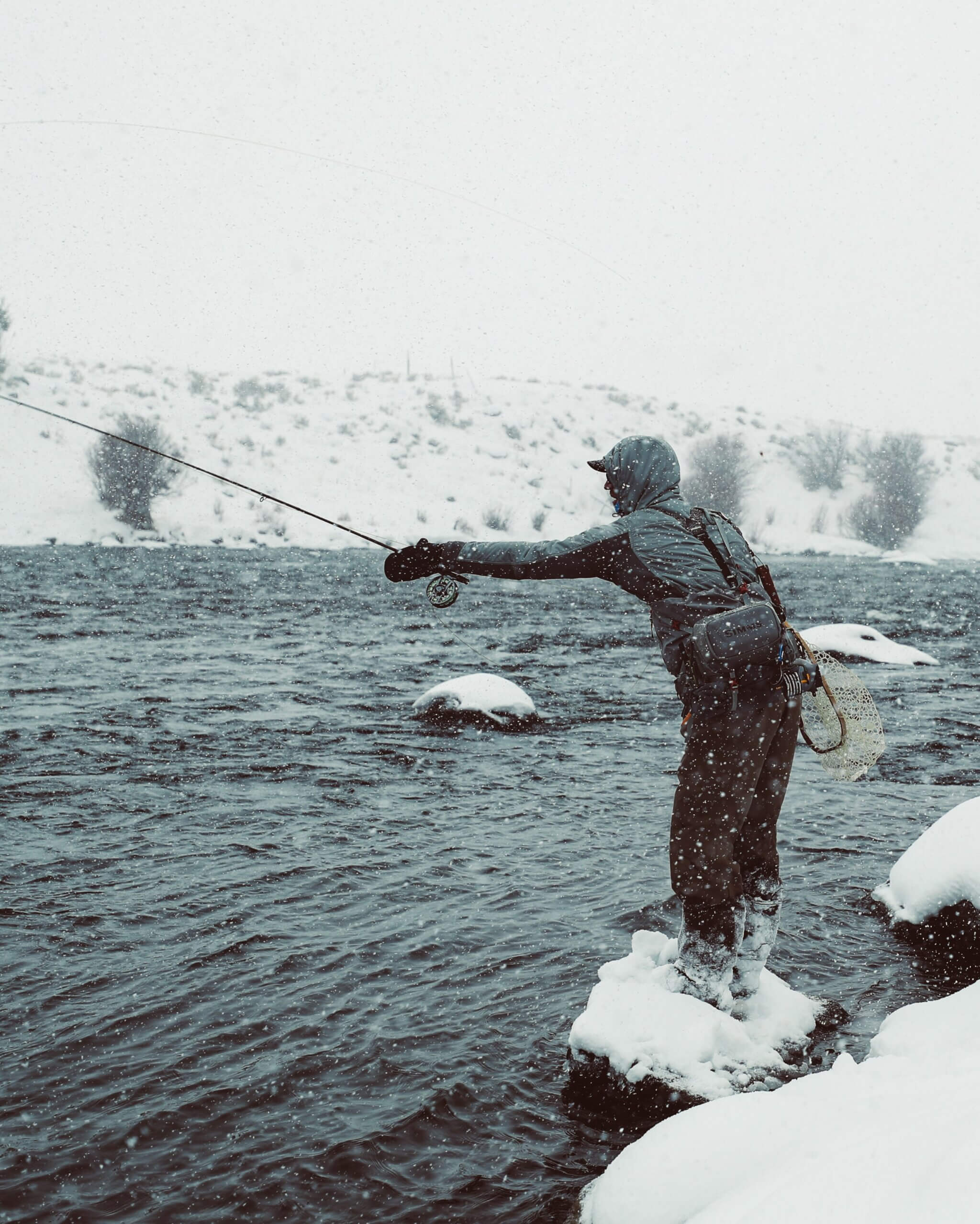 Man fly fishing in snowy conditions