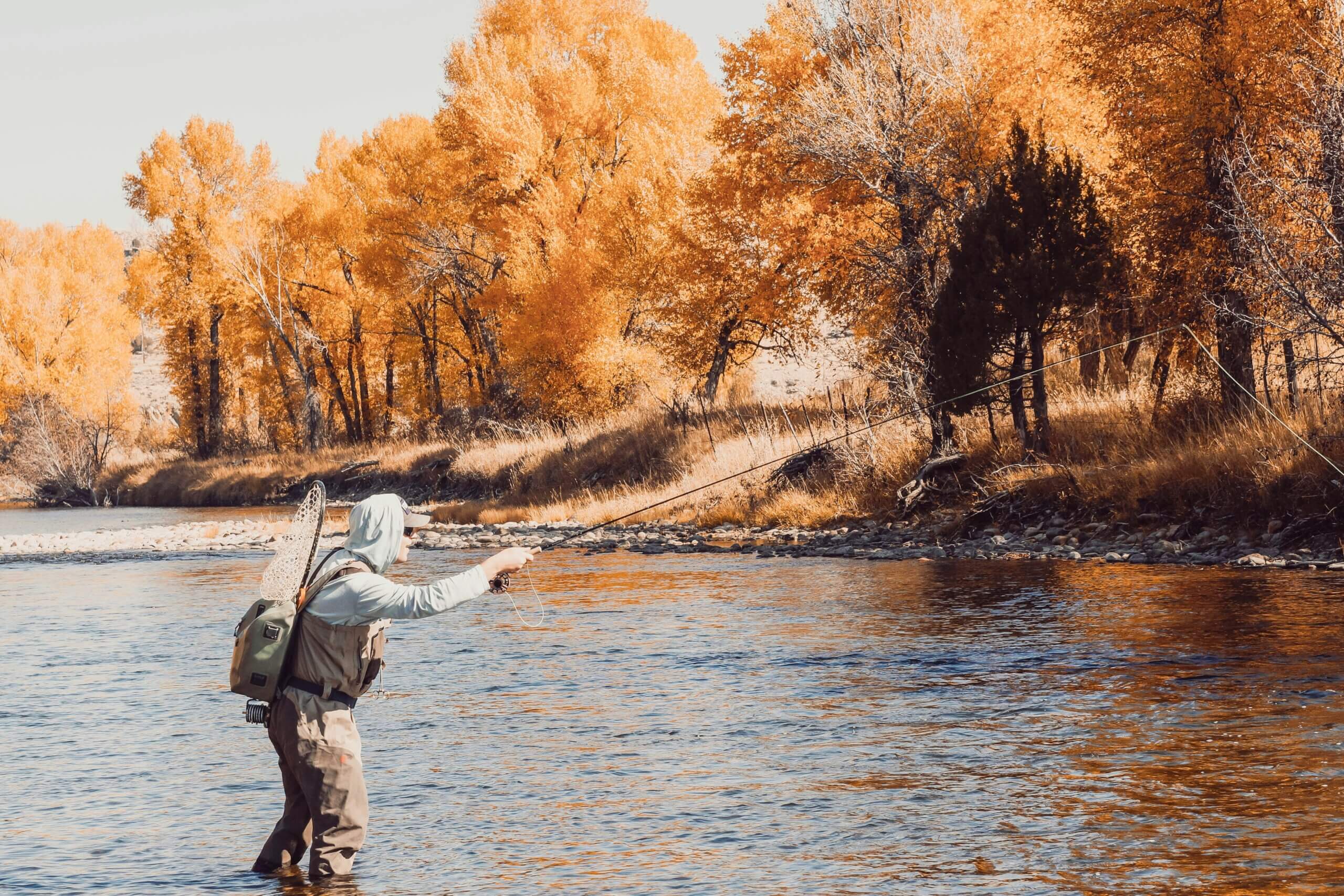 man casting on river in fall.